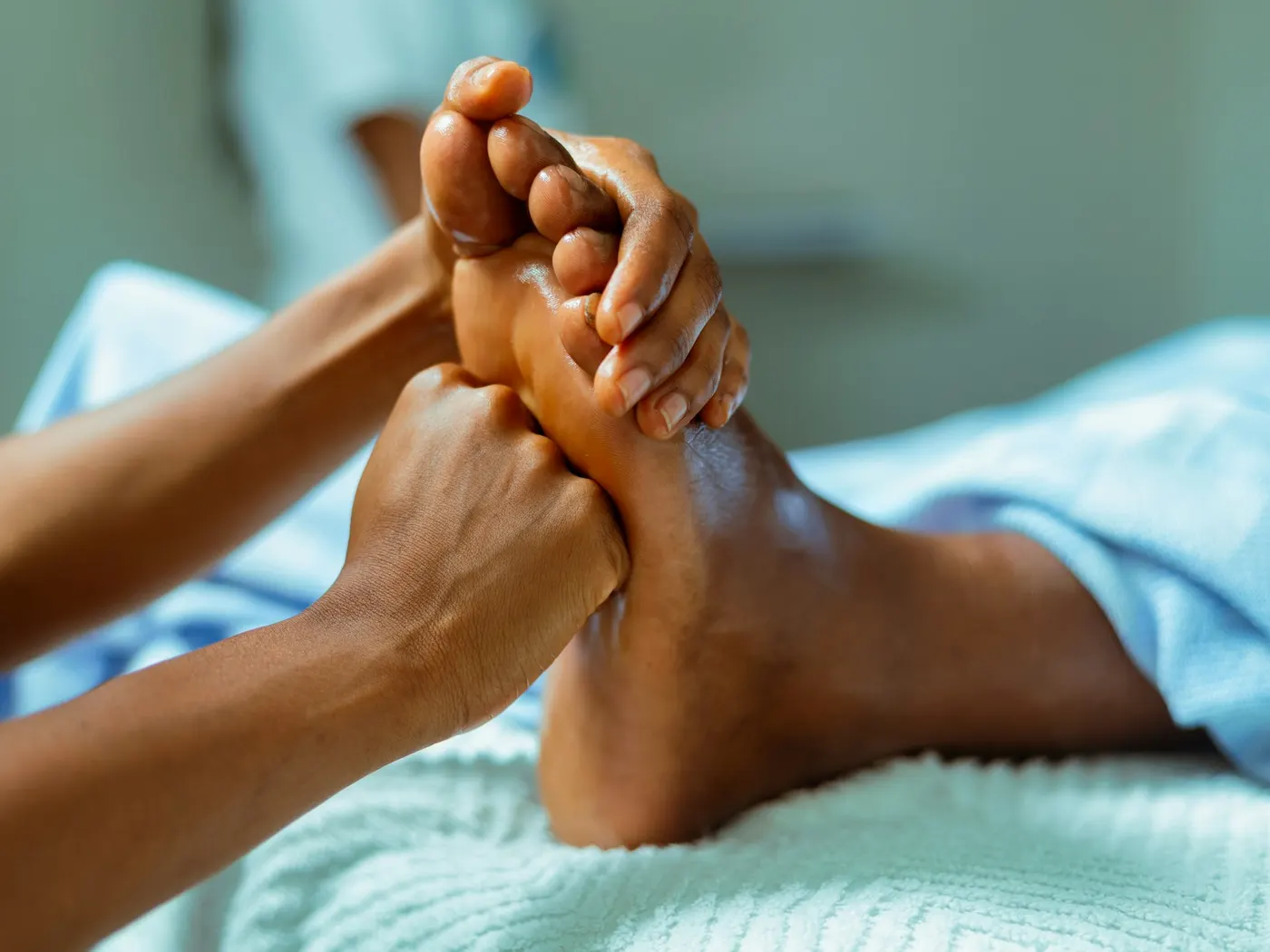 Therapist applying pressure to points on a client's foot during reflexology