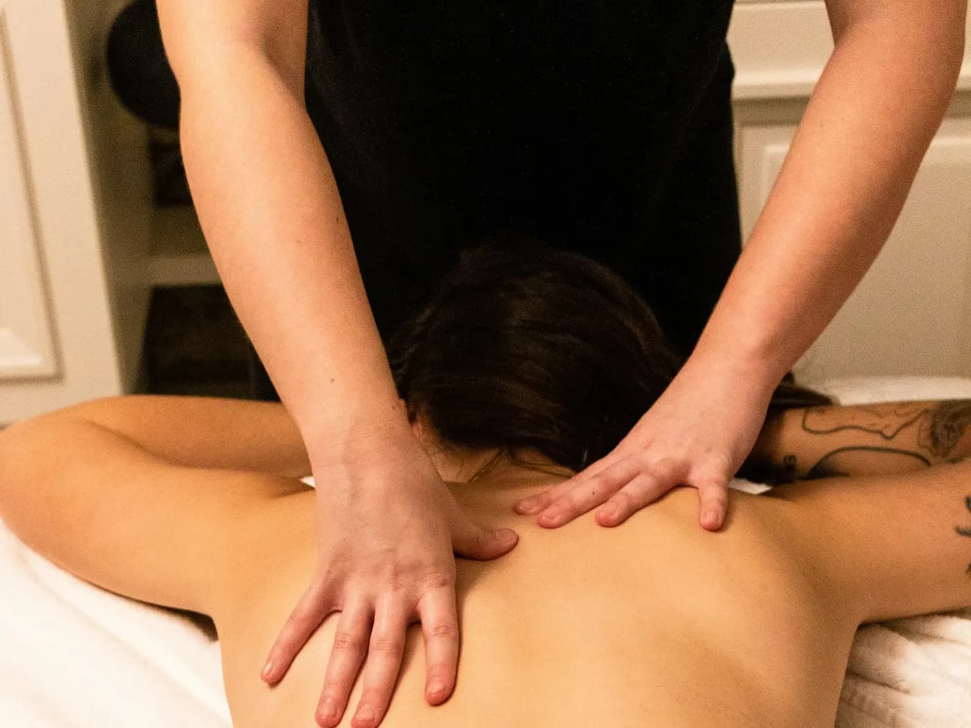 Therapist giving a client a gentle, relaxing back massage
