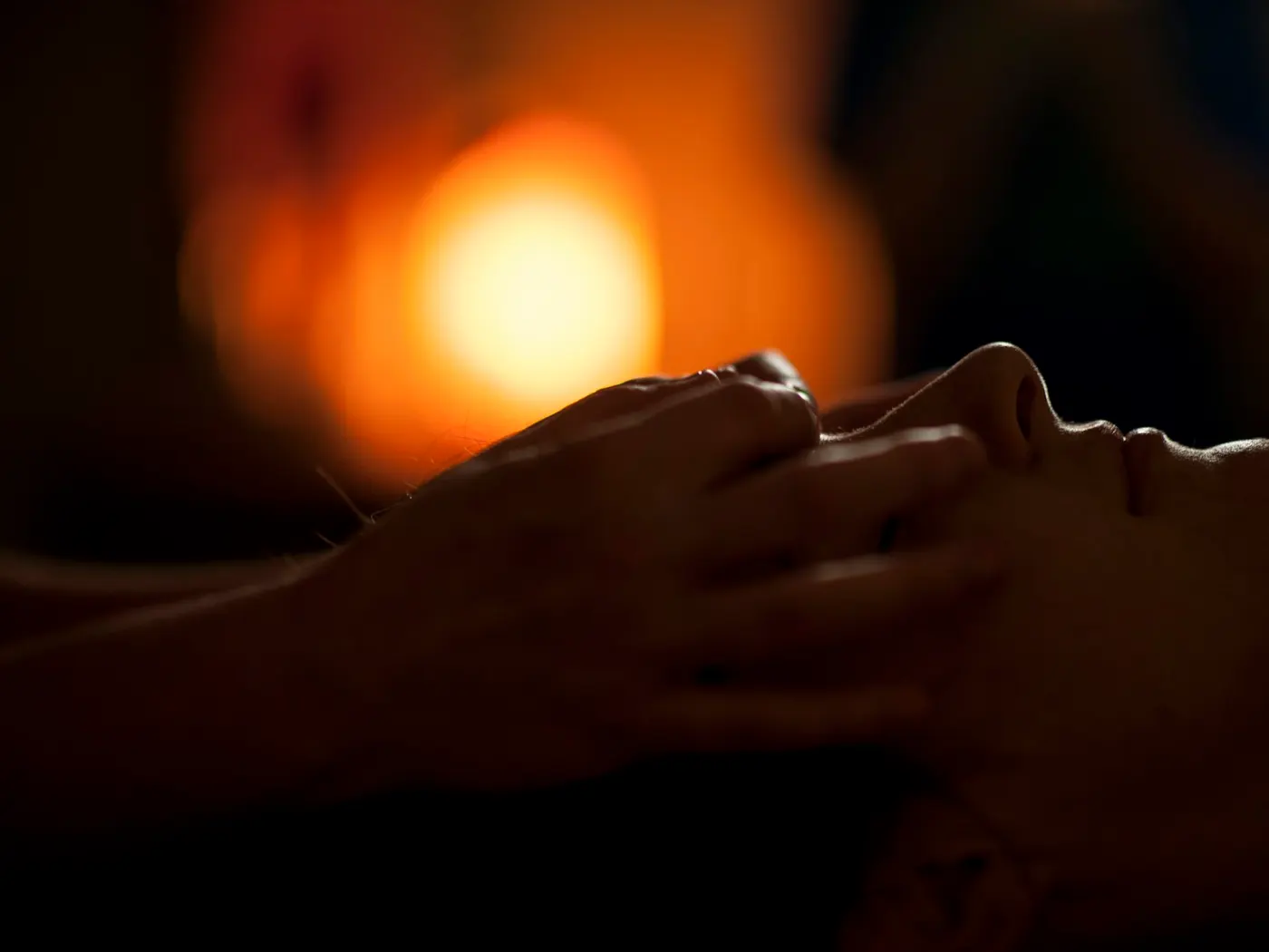 Client relaxing during a private candlelit massage experience